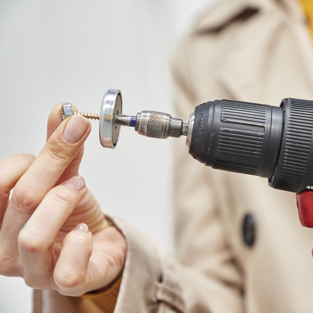 Close-up of hand installing magnetic mounting hardware for a modular whiteboard β showing easy, tool-friendly setup with precision parts.